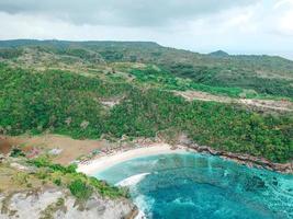 Aerial drone top view of coral beach and blue ocean waves In Nusa Penida, Bali, Indonesia. Overhead View Of Rocky Coast And Coves photo