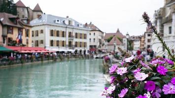 la vista del canal de la ciudad con edificios medievales en el casco antiguo de annecy, restaurante cerca del río tú en el casco antiguo, el edificio se ve genial en medio de una gran ciudad. foto