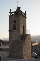 Medieval bell tower apart from the church with a beautiful light. Made of stone, with a staircase. photo