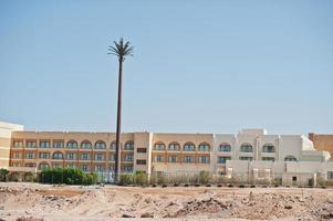 Building on sand with large radio station like palm photo