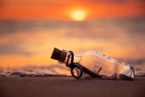 mensaje en la botella contra la puesta del sol foto