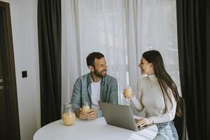 Young couple using laptop computer on the table in the living room photo