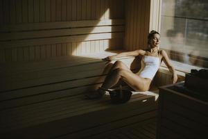 mujer joven relajándose en la sauna foto