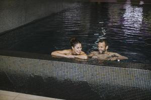 Young couple relaxing in a swimming pool photo