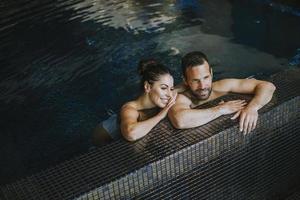 Young couple relaxing in a swimming pool photo