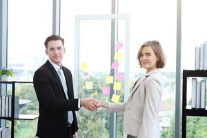 exitoso hombre de negocios y mujer de negocios felices y se dan la mano después de reunirse para asociarse en una oficina moderna foto