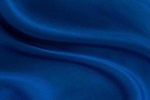 Fondo de tela azul profundo de lujo. Patrón de pliegue ondulado suave. Curva elegante. Textura de material de terciopelo de seda. foto