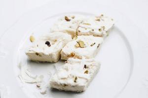 Turkish halva with pistachio on white background. photo