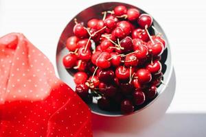 vista superior de cerezas frescas en un bol con tela roja