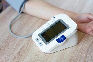 mujer usando un monitor de presión arterial digital foto