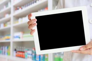 pharmacist showing tablet computer in the pharmacy photo