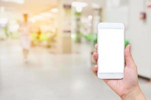 hand holding mobile smartphone with doctors and nurses in hospital photo