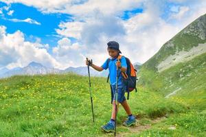 Child during alpine trekking in summer photo