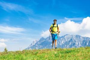 Young man practicing physical activity mountain and running with sticks photo