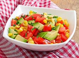 Mixed salad with avocado, tomatoes and sweet corn photo