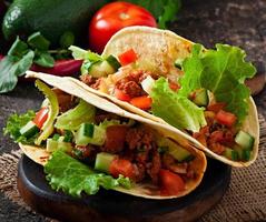 Mexican tacos with meat, vegetables and cheese photo