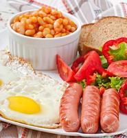 desayuno inglés - salchichas, huevos, frijoles y ensalada foto