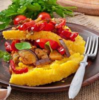 Polenta with vegetables - corn grits pizza with tomato and eggplant photo