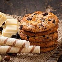 White chocolate, almonds and cookies on a wooden background