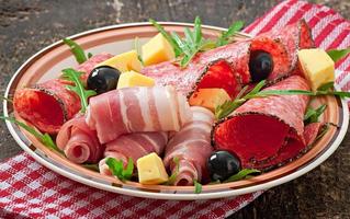 Meat appetizer on a plate on old wooden background photo