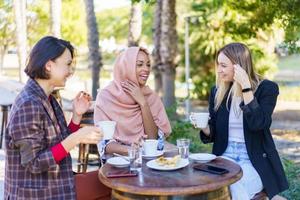 alegres mujeres multirraciales tomando café foto