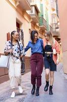 Stylish multiracial ladies walking home together photo