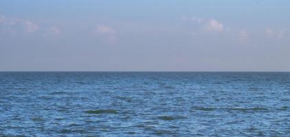 mar azul océano bajo un cielo azul con una nube blanca esponjosa paisaje marino naturaleza fondo verano viajes vacaciones foto