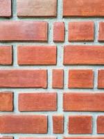 bloque de ladrillo cuadrado naranja en la pared de cemento con textura y fondo. Interiores fuertes casa edificio imagen vertical foto