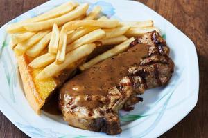 Close-up view of delicious porkchop, french fries and butter