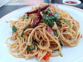 Spaghetti with Spicy pork and basil.Thai fusion food. side view photo