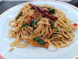 Spaghetti with Spicy pork, sausage and basil.Thai fusion food. side view photo