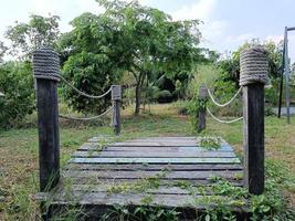 small wooden bridge in garden a beautiful green area for children to run and play. photo