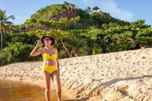 colocar mujeres en bikini amarillo en la playa conocida como pitinga, en arraial d ajuda, bahia, brasil foto