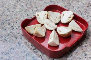 Straw mushrooms in a red tray are placed on a granite table. It is an edible and delicious mushroom that is beneficial to the body. It is cultivated in East Asia and Southeast Asia. photo