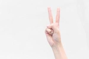 Hand of young woman shows two fingers as a fighting symbol on the  isolated white background. photo