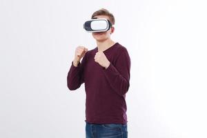 Young an wearing virtual reality goggles isolated on white background. VR glasses technology headset and boxing game. Copy space and mock up photo