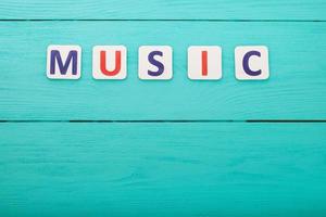 Word music with copy space on blue wooden background. Top view photo