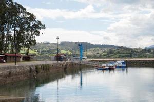 costa asturiana. pequeño puerto en el puntal con dos barcos. aguas tranquilas, cielo nublado foto