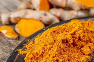 Orange turmeric powder with fresh turmeric photo