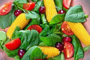 Close-up salad with spinach, tomatoes, corn and dogwood