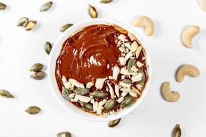 Top view dessert with condensed milk, cashews and pumpkin seeds on a white background photo