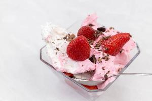 helado de fresa en el bol con fresas frescas foto