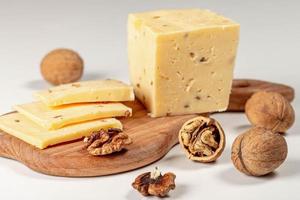 Pieces of cheese with walnuts on wooden kitchen Board photo