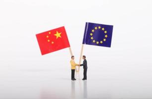 Two businessman shaking hands in front of flags of European Union and China