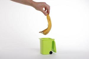 Hand putting banana peel in recycling bio bin
