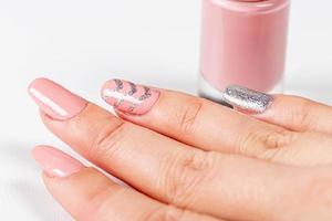 primer plano de la manicura rosa de una mujer con esmalte de uñas