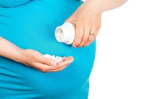 Closeup of pregnant woman's hands with pills. Consumption of pregnant calcium, vitamins photo