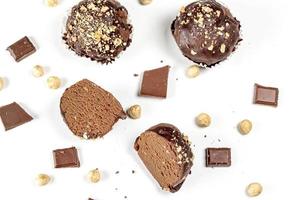 Chocolate cakes with chocolate pieces and hazelnuts on a white background