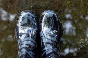 Rubber boots in a puddle, top view