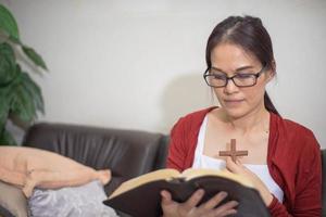 mujer asiática leyendo un libro en casa. espiritualidad y religión, conceptos religiosos